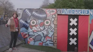 Presentator staat naast een graffiti kunstwerk op straat