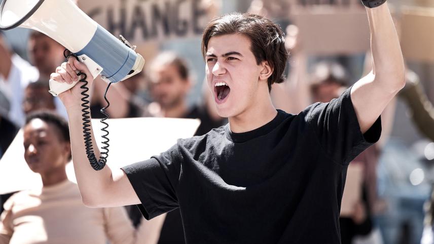 Foto van jongen met een megafoon die aan het roepen is.