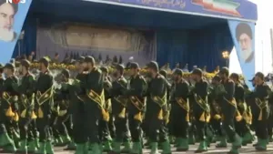 Foto van parade van soldaten die langs een podium lopen.