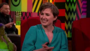 Een foto van schrijfster Maud Vanhauwaert in een rode stoel in een studio.