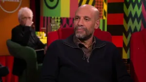 Een foto van schrijver Abdelkader Benali in een rode stoel in een studio. 