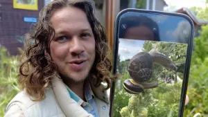 Een foto van presentator Pascal, hij laat op zijn telefoon een foto van een slak zien.