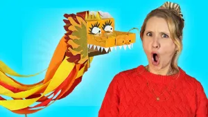 Foto van presentatrice Rosalie die geschrokken in de camera kijkt met een geknutselde draak naast zich met scherpe tanden.