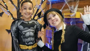 Foto van presentatrice Rosalie met jongen in batmanpak en zelfgeknutselde vleermuis.