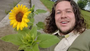 Een foto van presentator Pascal en een zonnebloem.