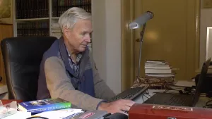 Foto van schrijver Jan Terlouw zittend aan een bureau.