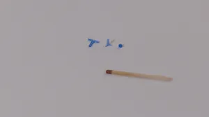 Een foto van drie verschillende oorbuisjes. Er ligt een lucifer naast om aan te geven dat ze kleiner zijn dan de kop van een lucifer. De ene is t-vormig, bij het middelste buisje zit er een extra stukje aan en het laatste buisje is een klein stukje buis.