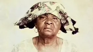 Surinaamse vrouw met traditionele doek op haar hoofd en ringen in haar oren