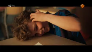 Jongetje ligt met hoofd op tafel. Hij houdt zijn arm bij zijn gezicht.