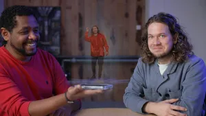 Een foto van presentator Pascal en een man aan een tafel, de man laat Pascal een hologram van Pascal zien.