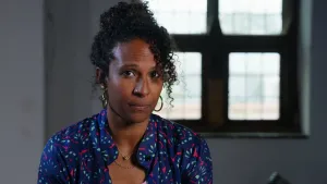 Presentatrice Astrid kijkt naar camera. Achter haar een raam.