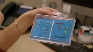 Foto van hand die doorzichtig koffertje vasthoudt waarin verschillende spiraaltjes liggen.