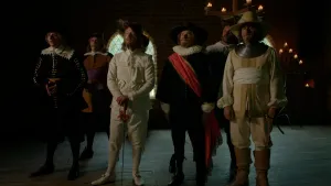 Foto van mannen in ouderwetse nette kleding zoals op De Nachtwacht van Rembrandt, ze kijken naar het schilderij waar ze op zijn geportretteerd, wat buiten beeld staat.