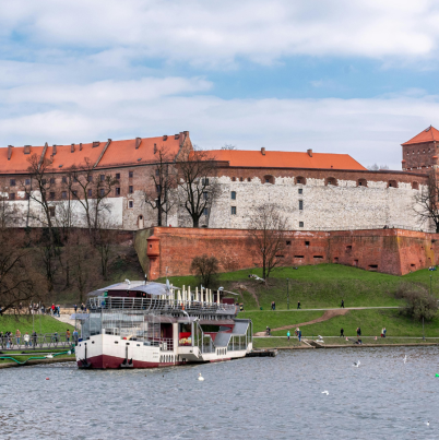 Een foto van een rivier met boot op de voorgrond, op de achtergrond zie je een burcht.