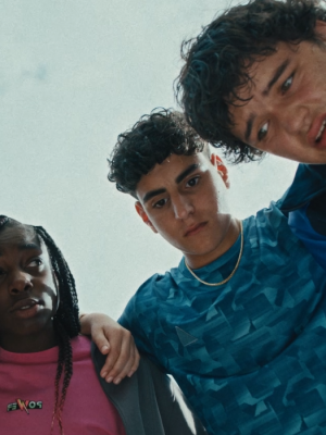 Een team staat in een kring met de armen om elkaars schouders, de foto is vanuit de kring genomen.