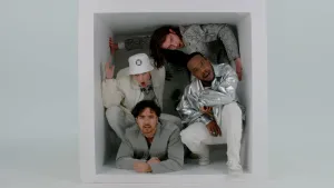 Foto van vier jongens in witte en zilveren kleding die in een wit vierkant zijn gepropt, om te symboliseren dat hokjesdenken beperkend is.