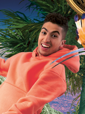 Foto van presentator Nizar in een oranje trui, hij staat naast een tyrannosaurus rex.