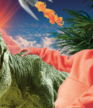 Foto van presentator Nizar in een oranje trui, hij staat naast een tyrannosaurus rex.