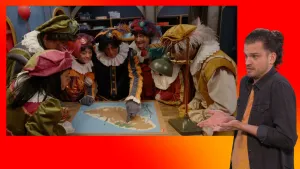 Pietje Paniek puzzelt samen met andere pieten. Naast het scherm staat een gebarentolk.