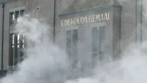 Foto van de gevel van het Woudagemaal waar stoom voor hangt.