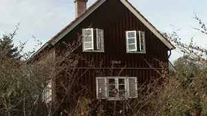 Foto van bruin houten huis met de naam 'Oslo' op de gevel.