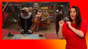 Pieten puzzels in het pakjesruim. Op de voorgrond Pietje Paniek. Naast het scherm staat de gebarentolk.