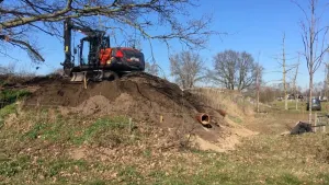 Een graafmachine bouwt een kunstburcht voor de dassen.