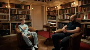 Twee jongens zitten in een bibliotheek.