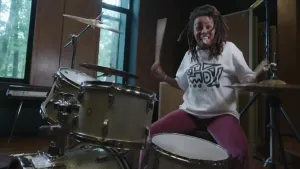 Presentator speelt de drums en trekt een gek gezicht.