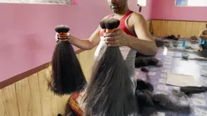 Een foto van een man die twee strengen haar op gang houdt.