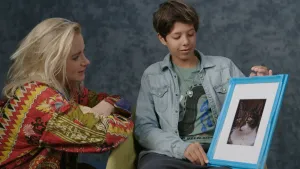 Een foto van een kind dat de foto van zijn hond aan presentatrice Janouk laat zien.