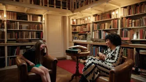 Een foto van twee meiden in stoelen in een grote bibliotheek