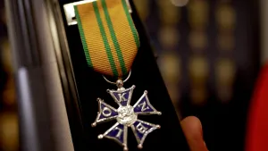 Closeupfoto van vierdaagsekruisje, vijfzijdige onderscheiding aan een geel-groen lintje.