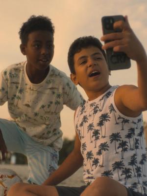Foto van twee jongens die een selfie maken op het strand.