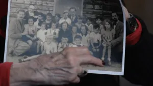 Foto van oude vrouw met een klassenfoto van 83 jaar geleden.