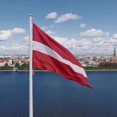 Foto van Letse vlag: rood, wit rood, wapperend in de wind aan het water bij Riga, de hoofdstad.