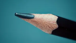 Closeupfoto van een grijs potlood op een turquoise achtergrond.