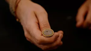 Foto van euromunt op een hand waarvan de duim op het punt staat de munt omhoog te gooien.