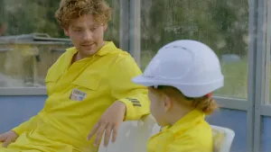 Foto van meisje met bouwhelm die samen met Soy Kroon zit.