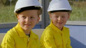Foto van twee jongetjes met bouwhelmen.
