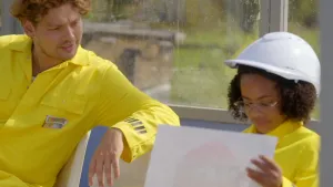 Foto van meisje met bouwhelm die samen met Soy Kroon zit.