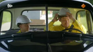 Foto van kind met bouwhelm die samen met Soy Kroon in een auto zit.