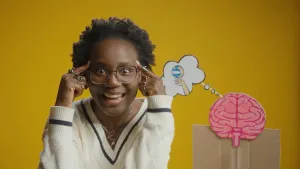 Foto van mevrouw naast van papier geknutselde hersenen.