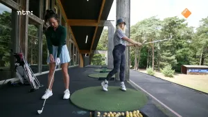Foto van presentatrice Janouk met golfster op een golfbaan aan het oefenen met slaan.