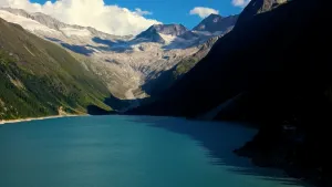Foto van een blauw stuwmeer in de Alpen, meer omringd door bergen.