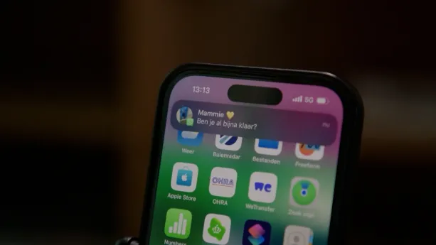 Foto van smartphone waarop een melding binnenkomt, een berichtje van mammie: ben je bijna klaar?