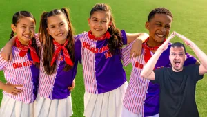 Foto van vier kinderen van kinderen voor kinderen op een groen sportveld met daarvoor gebarentolk die met zijn handen boven zijn hoofd een huisje vormt.