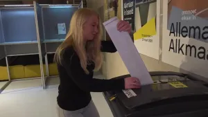 Foto van meisje die stembiljet in een stembus steekt