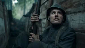 Foto van bang kijkende soldaat met geweer in loopgraaf tijdens de Tweede Wereldoorlog op de Grebbeberg.