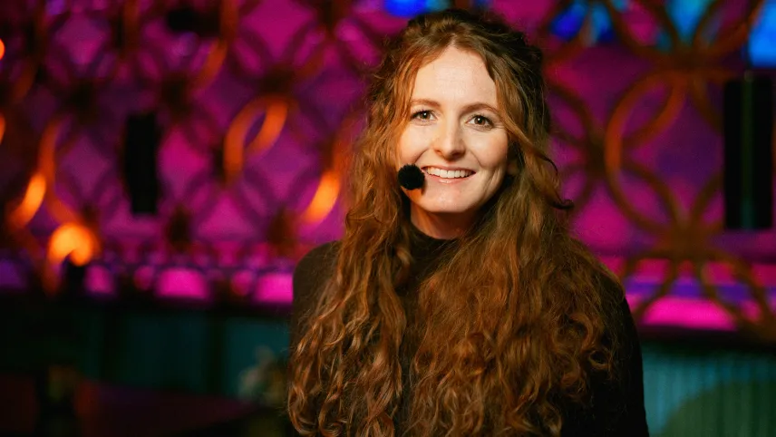 Een foto van een vrouw met een microfoontje op haar gezicht.